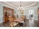 Dining room with hardwood floors, crown molding, elegant chandelier, and beautiful china cabinet at 210 Little River Farms Trl, Canton, GA 30115