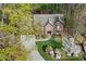 Aerial shot of a brick home with a two-car garage and meticulously landscaped front yard in a lush setting at 2702 Long Lake Ne Ter, Roswell, GA 30075