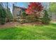 Expansive backyard featuring lush green grass, mature trees, and terraced landscaping with stone accents at 2702 Long Lake Ne Ter, Roswell, GA 30075