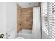 Well-lit bathroom with a bathtub-shower combination and modern fixtures, and wood-look tile at 2702 Long Lake Ne Ter, Roswell, GA 30075