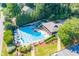 Community pool with lounge chairs and tables, surrounded by lush landscaping and trees with parking area at 2702 Long Lake Ne Ter, Roswell, GA 30075