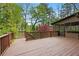 Spacious wood deck with railing offers ample space for outdoor seating and entertaining amid mature trees at 2702 Long Lake Ne Ter, Roswell, GA 30075