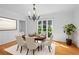 Elegant dining room with a round table set for six, complemented by a stylish chandelier and hardwood floors at 2702 Long Lake Ne Ter, Roswell, GA 30075
