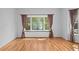 Empty room with pristine hardwood flooring and large bay windows offering ample natural light and views of the outdoors at 2702 Long Lake Ne Ter, Roswell, GA 30075