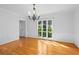 Bright, empty dining room featuring hardwood floors, detailed trim, a chandelier, and a view to the outdoors at 2702 Long Lake Ne Ter, Roswell, GA 30075