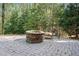 Charming outdoor stone fire pit with a bench, surrounded by mature trees for a serene setting at 2702 Long Lake Ne Ter, Roswell, GA 30075