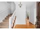 Bright foyer features hardwood floors, a staircase with white railing, and a decorative chandelier at 2702 Long Lake Ne Ter, Roswell, GA 30075