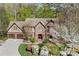 Charming brick home with a well-manicured front yard, a two-car garage, and mature flowering trees at 2702 Long Lake Ne Ter, Roswell, GA 30075