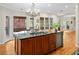 An island stands tall in a kitchen area, featuring a granite countertop and wooden cabinets at 2702 Long Lake Ne Ter, Roswell, GA 30075
