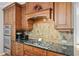 Close up of the kitchen with wooden cabinets, stainless steel appliances, and a tile backsplash at 2702 Long Lake Ne Ter, Roswell, GA 30075