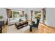 Bright living room with a modern sofa, dark wood coffee table and a large window showcasing the outdoor greenery at 2702 Long Lake Ne Ter, Roswell, GA 30075