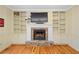 Fireplace with stone surround flanked by built-in shelving and cabinets at 2702 Long Lake Ne Ter, Roswell, GA 30075