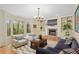 A cozy living room with a fireplace, built-in shelves, and a bay window overlooking nature at 2702 Long Lake Ne Ter, Roswell, GA 30075