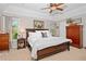Well-lit main bedroom with a ceiling fan, windows and a queen-size bed with reading lamps and wood furnishings at 2702 Long Lake Ne Ter, Roswell, GA 30075