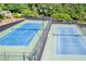 Community tennis courts with blue surface and green trim, fenced in and surrounded by trees at 2702 Long Lake Ne Ter, Roswell, GA 30075