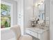 Charming vanity area with makeup mirror, natural light, white drawers and a white chair perfect for relaxing at 2702 Long Lake Ne Ter, Roswell, GA 30075