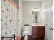 Cozy bathroom features wood floors, a vanity with storage, a toilet, and a shower with a patterned curtain at 5040 Mundy Ct, Cumming, GA 30028