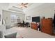 Spacious bedroom with tray ceiling, carpet, sofa, dresser, and large window at 5040 Mundy Ct, Cumming, GA 30028