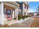 Inviting entryway showcases a brick facade, a red door, and manicured landscaping at 5040 Mundy Ct, Cumming, GA 30028