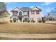 Charming two-story home features a brick facade, well-manicured lawn, and welcoming red door at 5040 Mundy Ct, Cumming, GA 30028