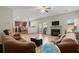 Inviting living room featuring a cozy fireplace, TV, ceiling fan and open access to the kitchen and backyard at 5040 Mundy Ct, Cumming, GA 30028