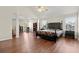 Spacious main bedroom featuring wood floors, a ceiling fan, and large windows for ample natural light at 5040 Mundy Ct, Cumming, GA 30028