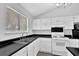 Bright kitchen featuring white cabinets, black countertops and a window at 3954 Springleaf Pt, Stone Mountain, GA 30083