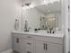 Modern bathroom features a double vanity with sleek black fixtures and a large illuminated mirror at 2046 Drew Dr, Atlanta, GA 30318