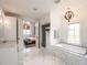Elegant bathroom featuring marble floors, a soaking tub, and an open view to the Primary bedroom at 405 9Th Ne St, Atlanta, GA 30309