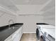 Well-lit laundry room with modern washer and dryer, granite counters, sink, and shelving for organized storage at 405 9Th Ne St, Atlanta, GA 30309