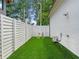 Neat side yard with synthetic grass, white fencing, and space for outdoor activities or storage at 405 9Th Ne St, Atlanta, GA 30309
