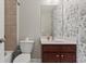 Bathroom featuring a toilet, sink with wallpaper and a combination shower and tub at 6040 Ashborough Park, Cumming, GA 30040