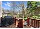 The wooden back deck with black grill overlooks the meticulously kept lawn at 12350 Broadleaf Ln, Johns Creek, GA 30005