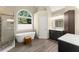 Bright bathroom featuring a glass shower, soaking tub, vanity, and a large window at 12350 Broadleaf Ln, Johns Creek, GA 30005