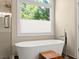Bathroom featuring a soaking tub, window, and glass shower with stone details at 12350 Broadleaf Ln, Johns Creek, GA 30005