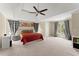 Large bedroom boasts large windows, neutral carpet, and a ceiling fan at 12350 Broadleaf Ln, Johns Creek, GA 30005
