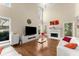 Bright living room features a fireplace, large windows, and hardwood floors at 12350 Broadleaf Ln, Johns Creek, GA 30005