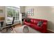 Cozy office space with a bright window, red couch, and neutral decor at 12350 Broadleaf Ln, Johns Creek, GA 30005