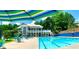 Community pool with turquoise water, seating and shade umbrellas with clubhouse at 12350 Broadleaf Ln, Johns Creek, GA 30005
