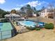 A stunning view of the community pool, tennis courts, and surrounding landscaping creates a relaxing outdoor oasis at 12350 Broadleaf Ln, Johns Creek, GA 30005