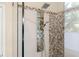 Shower featuring multiple shower heads, shelving, and decorative stone trim at 12350 Broadleaf Ln, Johns Creek, GA 30005