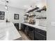 The bar area features modern shelving for drinks, a marble countertop, and sleek, dark cabinets, perfect for entertaining guests at 4183 Hill House Sw Rd, Smyrna, GA 30082