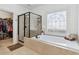 Soaking tub and glass shower with decorative window and access to walk-in closet at 4183 Hill House Sw Rd, Smyrna, GA 30082