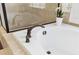 Close-up on soaking tub with bronze faucet, walk-in shower, and decorative window at 4183 Hill House Sw Rd, Smyrna, GA 30082