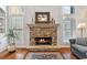 Cozy living room featuring a stone fireplace, hardwood floors, bright windows, and comfortable furniture at 4183 Hill House Sw Rd, Smyrna, GA 30082