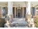 Inviting front porch with stone pillars, neutral colors, elegant light fixtures and a welcoming front door at 4183 Hill House Sw Rd, Smyrna, GA 30082