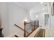 Bright hallway with decorative wrought iron railing, neutral walls, and a carpet runner at 4183 Hill House Sw Rd, Smyrna, GA 30082