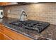 Close up on kitchen cooktop with granite countertops and tile backsplash at 4183 Hill House Sw Rd, Smyrna, GA 30082