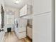 Bright laundry room with a modern washer and dryer, white cabinets, and wood-look flooring offers plenty of storage at 4183 Hill House Sw Rd, Smyrna, GA 30082
