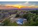 Aerial view of a property with a sunset, light blue house, and surrounded by mature trees at 5761 Dixie Hwy, Rutledge, GA 30663